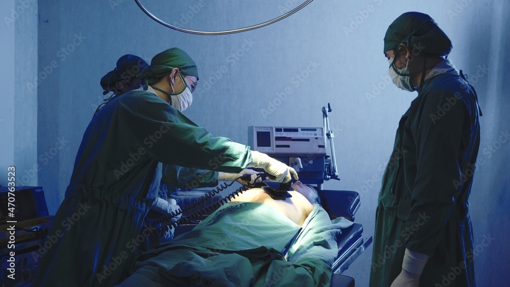 Defibrillation cardiac dysrhythmia, Surgical doctor team performing surgery patient on operating