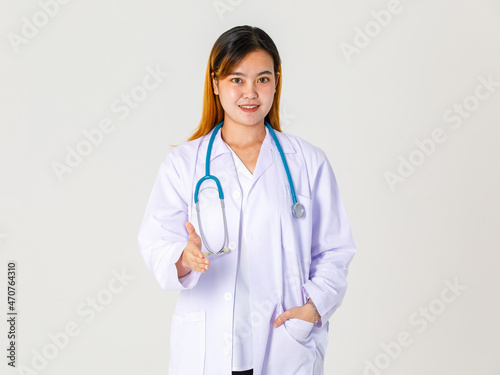 Portrait studio shot of Asian successful professional female clinical doctor in lab coat uniform hanging stethoscope around neck standing smiling and give hand for shaking