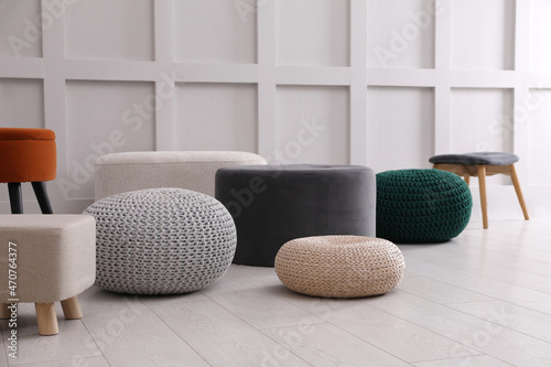 Fotografía Different stylish poufs and ottomans near white wall