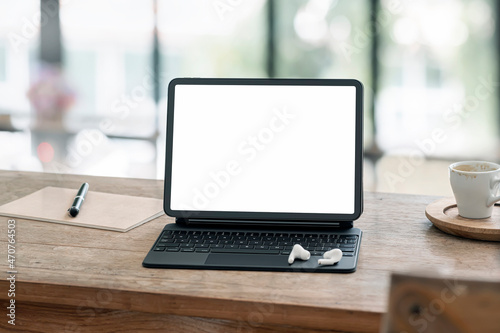 Mockup blank white screen portable tablet on wooden table.