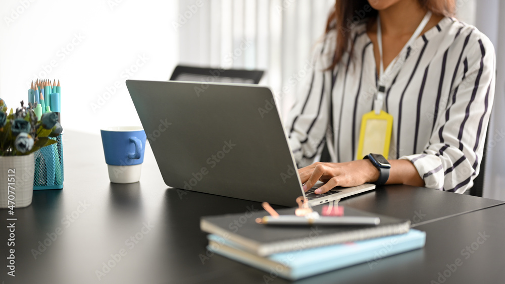 Female in a business strategy team working on her laptop computer Female in a business strategy team working on her laptop computer