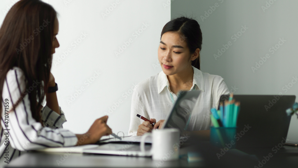 Two of professional female business workers discussing business strategy plan at the office Two of professional female business workers discussing business strategy plan at the office