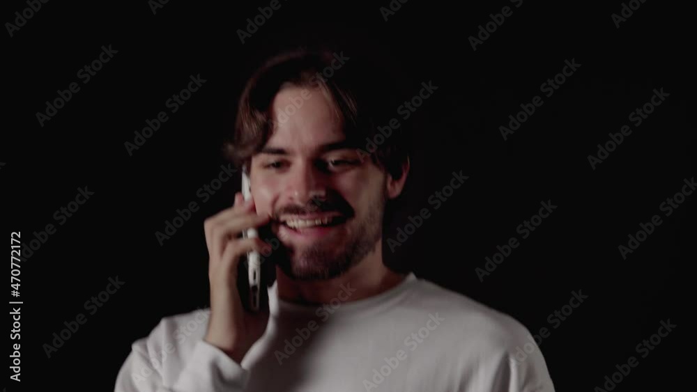 Trendy Young Man excited on phone call, cheering gestures, close, black background Trendy Young Man excited on phone call, cheering gestures, close, black background