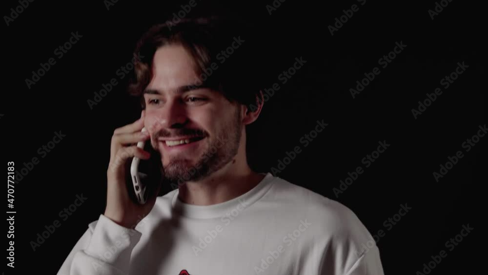 Trendy Young Man excited on smart phone, cheering gestures, close, black background Trendy Young Man excited on smart phone, cheering gestures, close, black background