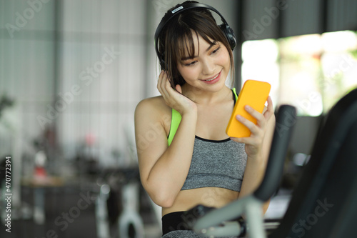 Beautiful sporty girl listening music during exercise workout at the gym.