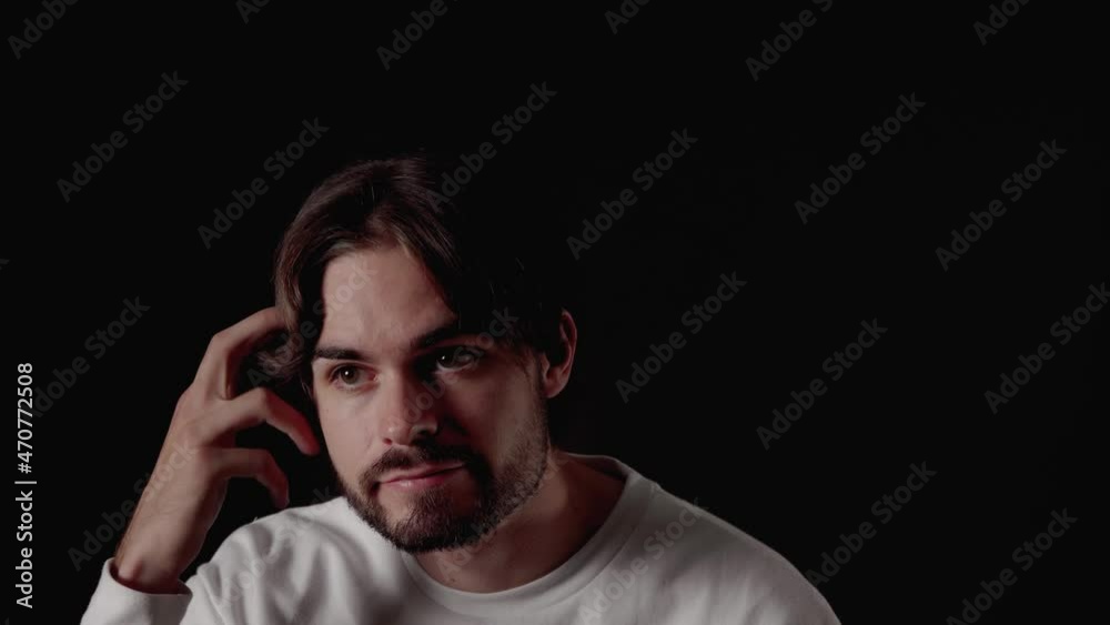 Trendy Young Man expressing disappointment, lack of surprise, close, black background Trendy Young Man expressing disappointment, lack of surprise, close, black background