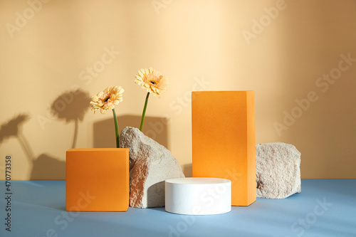 Front view of white and orange podium with and flower in a beige background for advertising , abstract content