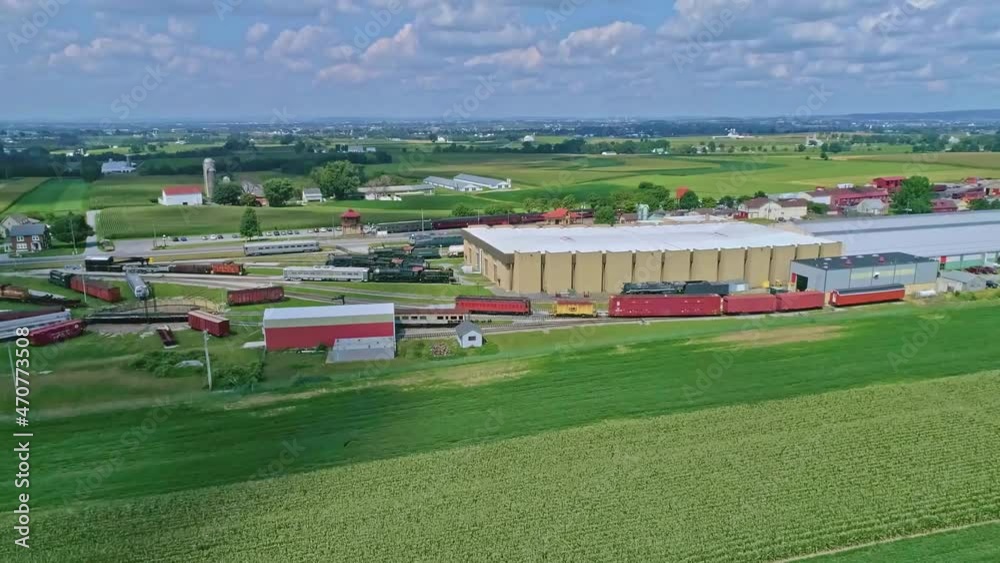 An Aerial Traveling View of Corn Fields and Harvesting Crops, With a Train Yard and Patches of Color on a Beautiful Summer Day An Aerial Traveling View of Corn Fields and Harvesting Crops, With a Train Yard and Patches of Color on a Beautiful Summer Day