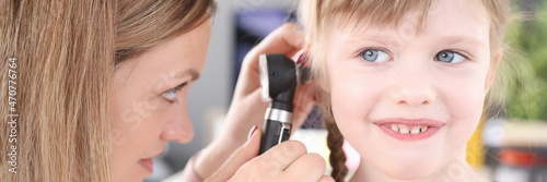 Otorhinolaryngologist conducts medical examination of little girl ear