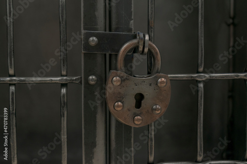 Old padlock on a metal grate. Vintage style. Concept of closedness, safety. photo