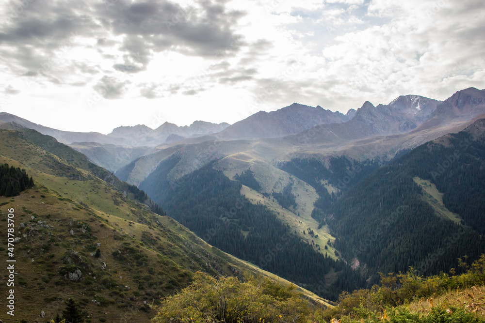 Beautiful Summer landscape: blue cloudy sky, green hills and distant mountains