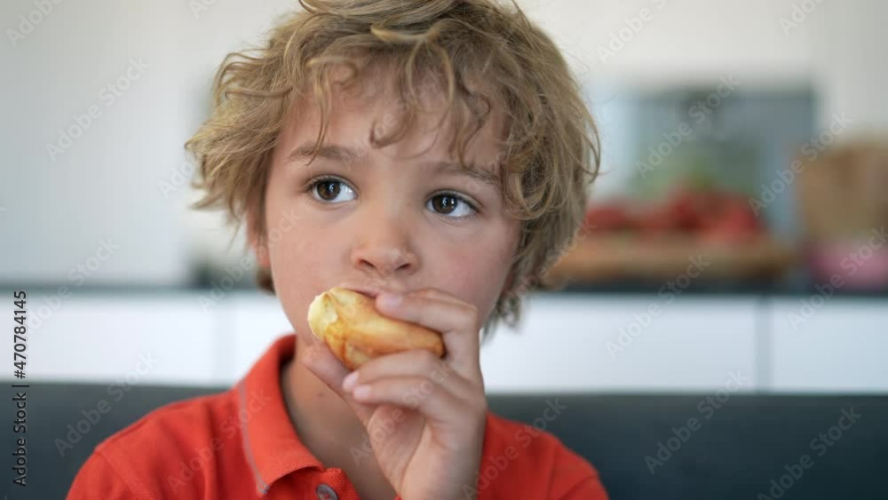 Little boy eating bread carb. Child eats piece of bread for breakfast Little boy eating bread carb. Child eats piece of bread for breakfast