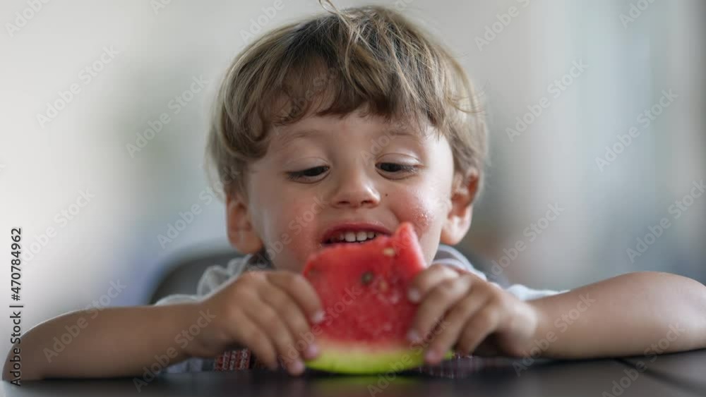 Little boy eating watermelon fruit. Child eats healthy fruit dessert Little boy eating watermelon fruit. Child eats healthy fruit dessert