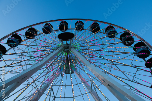 Part of Ferris wheel on blue background night sky. 