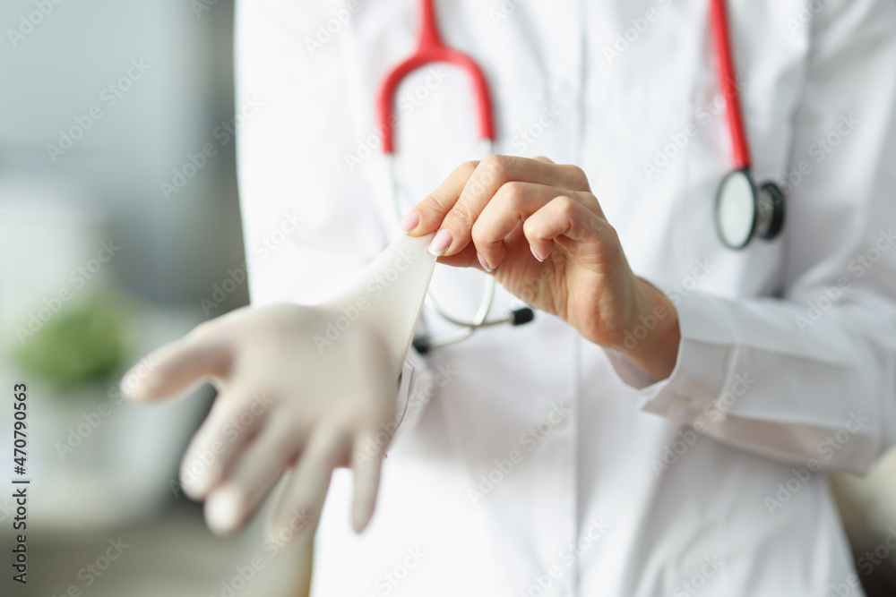 Doctor or nurse putting on sterile gloves before work in clinic