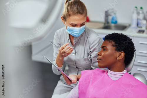 Female dentist explaining Tooth X-Rays to a african patient photo