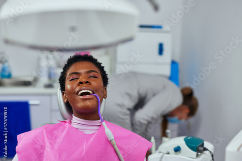 African female patient at dentist with pump in her mouth