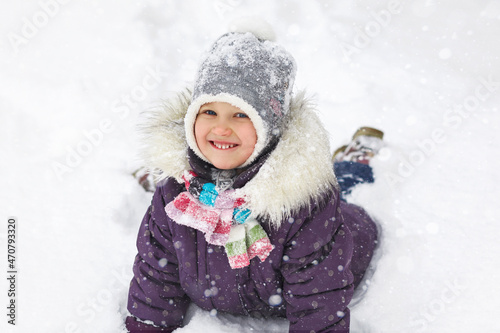 Winter child in snow. Active holidays in winter. Winter Joyful Walking Happyness in white snow. Happy girl portrait in winter clothes.