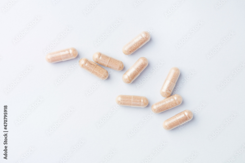 Hop Extract Capsules. Bright paper background. Top view. Close up. Hop Extract Capsules. Bright paper background. Top view. Close up.