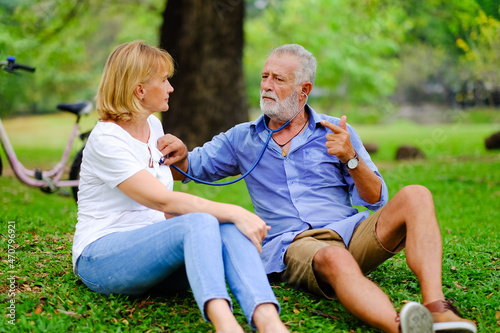 senior woman take care old man That is tired from exercise in park