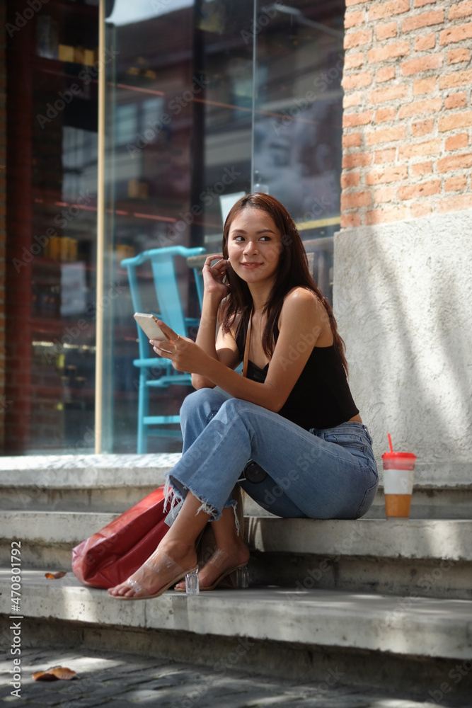 Portrait of smiling woman sitting at outdoor and using smart phone. Portrait of smiling woman sitting at outdoor and using smart phone.