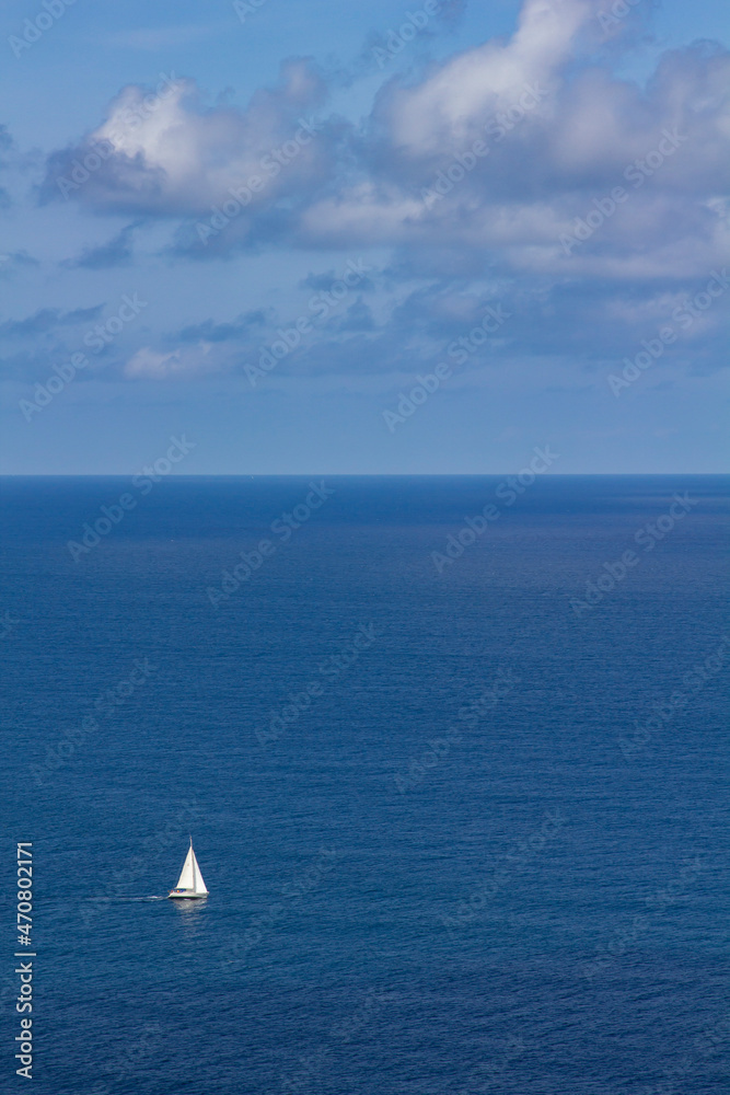 sailboat at sea sails in solitude on a sunny day. copy space, copy text. concept of freedom and opportunities