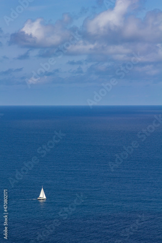 sailboat at sea sails in solitude on a sunny day. copy space, copy text. concept of freedom and opportunities © Berto