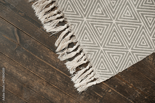 grey smooth rug with geometric shapes on stylish dark wooden parquet. scandinavian style home accessories. selective focus