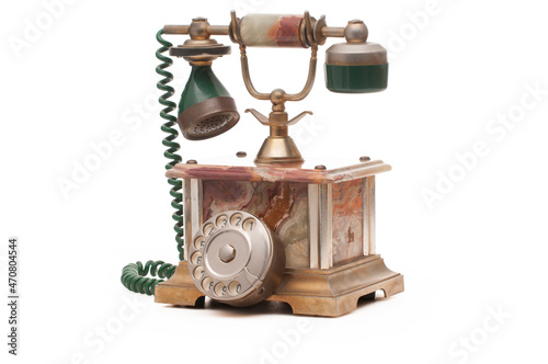Antique telephone in brass and marble on white background