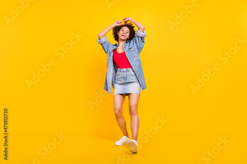 Full length photo of happy dark skin joyful woman enjoy smile dance cool isolated on shine yellow color background