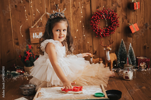 little happy girl celebrating christmas and making cookies