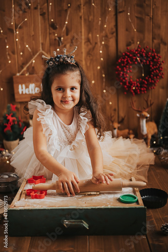 little happy girl celebrating christmas and making cookies photo