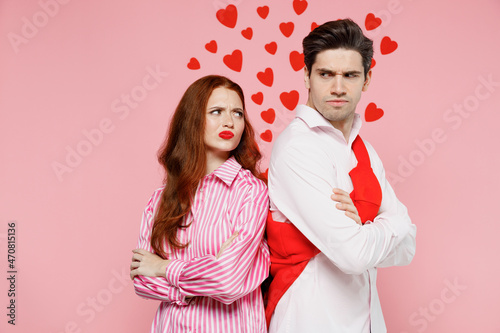 Young offended sad couple two friends woman man in casual shirt hold hands crossed folded stand back to back isolated on plain pastel pink background. Valentine's Day birthday holiday party concept