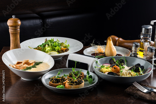 Italian risotto with roasted chicken, snacks on dark wooden table. Italian food table, top view