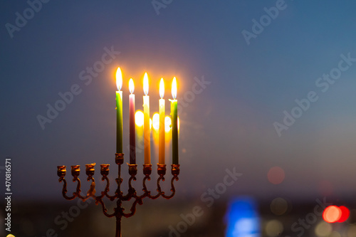 fourth day of Hanukkah. Light four candles in the menorah. Hannukia on the windowsill. Traditions of the religion of Judaism. The main holiday of the Jews. Sunset night photo