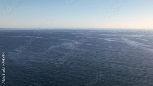 Aerial view of a blue sea water background and sun reflections. Aerial flying drone view. Waves water surface. Flight over the ocean. Aerial ocean view. Top fly over the sea. Penobscot County, Maine,  photo