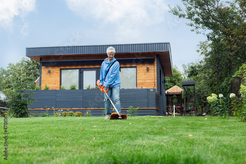 Woman mowing lawn in backyard
