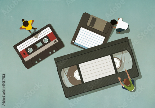 People looking at antiquated cassette and VHS tapes
