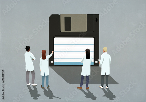 Scientists in lab coats looking at floppy disk
 photo