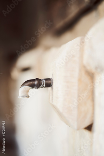 Paint on faucet at stone wall
 photo