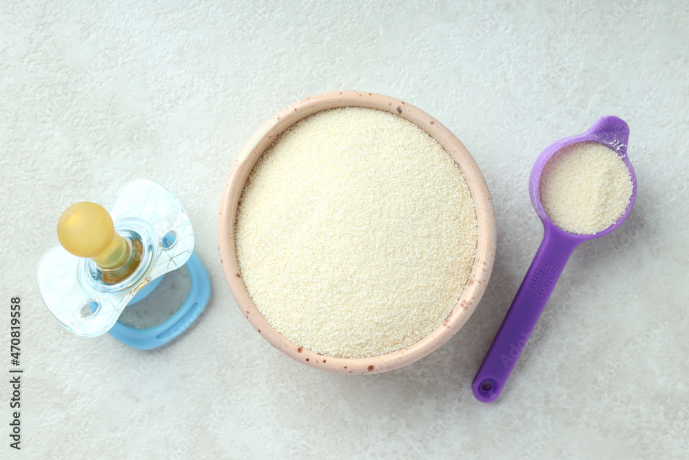 Concept of baby food with рowdered milk on white textured background Concept of baby food with рowdered milk on white textured background