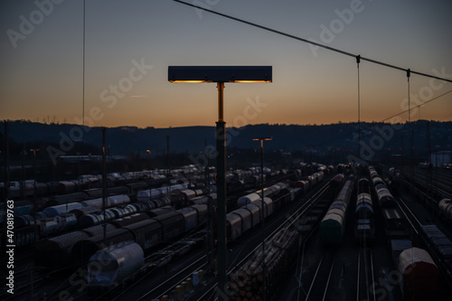 Dusk panorama of switch yard in Hagen Vorhalle, Germany. multiple freight trains and waggons are standing on the rails.