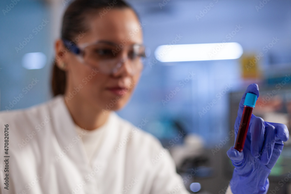 Specialist doctor holding medical test tube with blood sample analyzing dna expertise working in pharmaceutical hospital laboratory, Chemist researcher developing vaccine against coronavirus Specialist doctor holding medical test tube with blood sample analyzing dna expertise working in pharmaceutical hospital laboratory, Chemist researcher developing vaccine against coronavirus