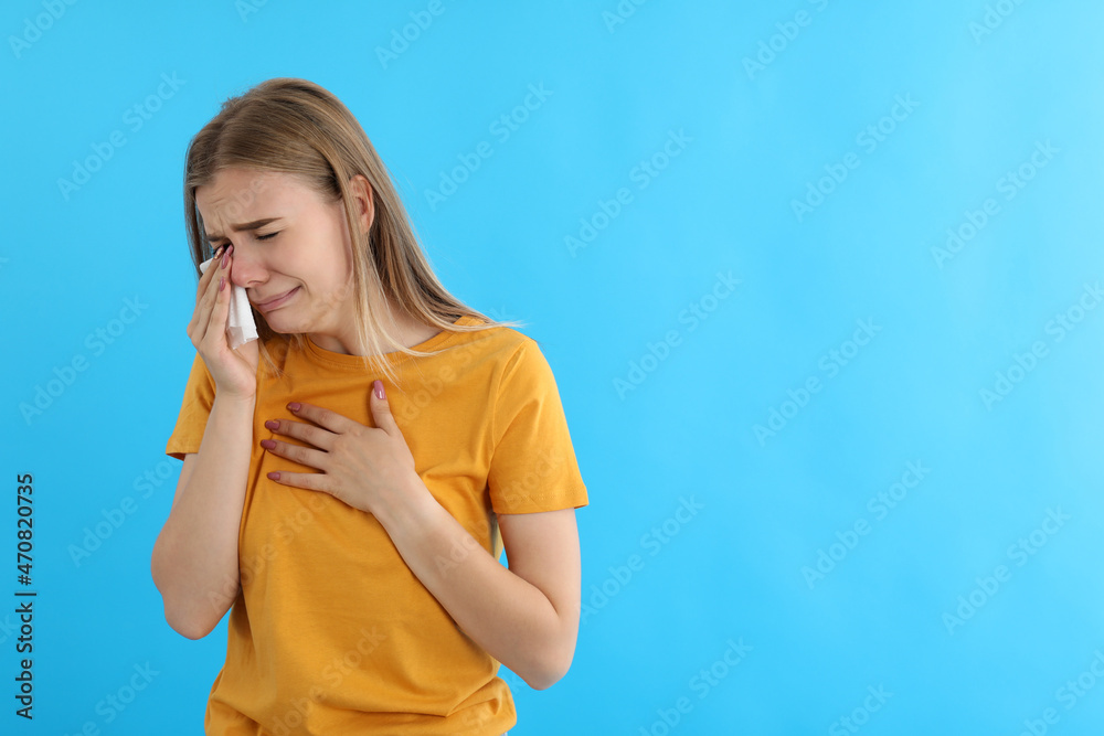 Crying girl in t-shirt on blue background Crying girl in t-shirt on blue background
