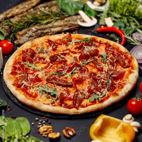 Top view pizza on table top, Flat lay of pizza on black background, Prepared pizza on table for serve Freshly baked homemade pizza isolated on a black background with vegetables. View from above
