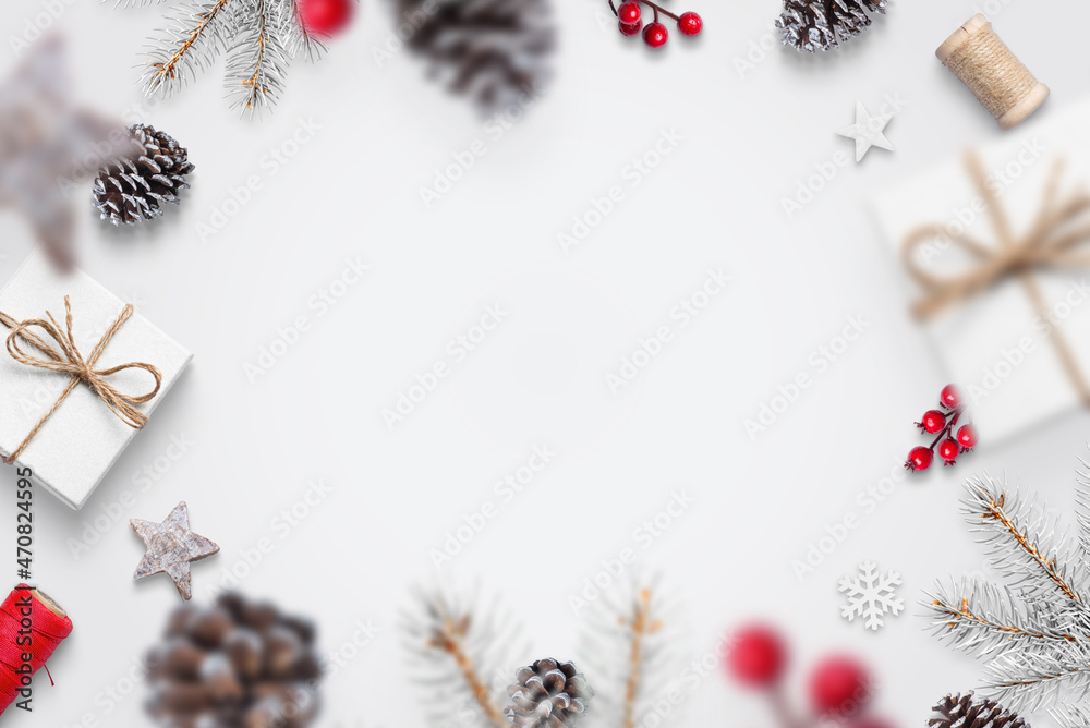 Christmas decorations fall on the white table concept. Gifts, pine, cones, red berries, tree branches, snowflakes. Top view, flat lay, greeting card concept