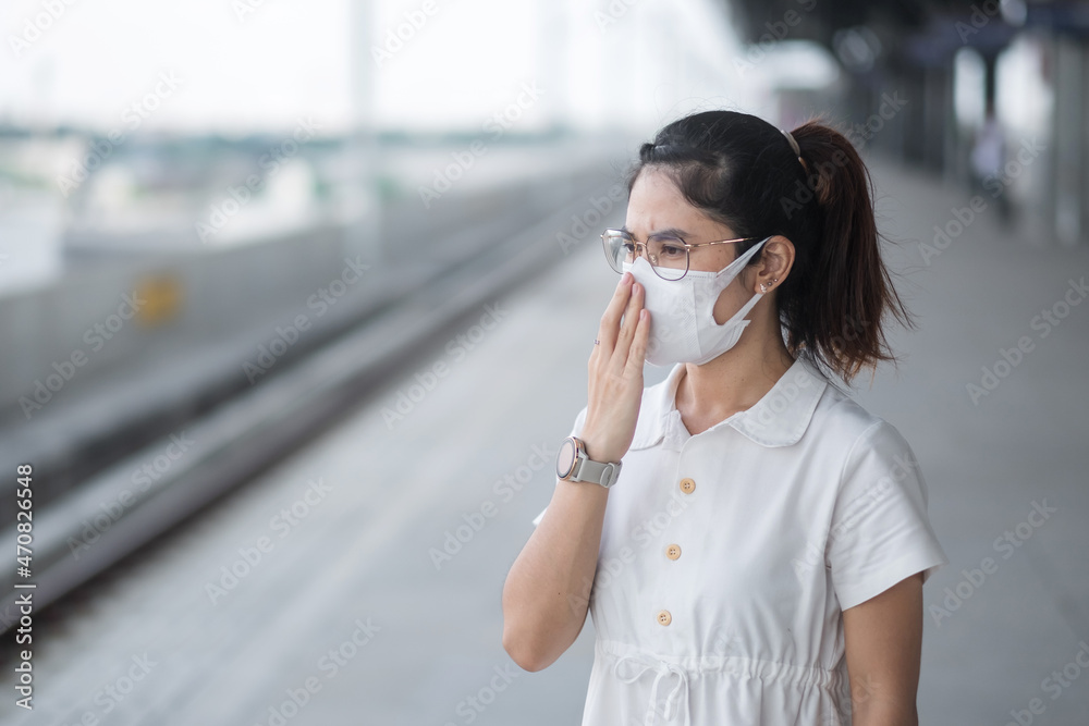 woman wearing Protective face mask prevention coronavirus and PM 2.5 pollution during waiting train. public transportation. safety under covid-19 pandemic and dust woman wearing Protective face mask prevention coronavirus and PM 2.5 pollution during waiting train. public transportation. safety under covid-19 pandemic and dust