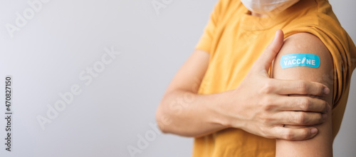woman showing bandage after receiving covid 19 vaccine. Vaccination, herd immunity, side effect, booster dose, vaccine passport and Coronavirus pandemic