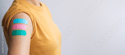 woman showing plaster after receiving covid 19 vaccine. Vaccination, herd immunity, side effect, booster dose, vaccine passport and Coronavirus pandemic