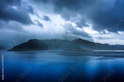 lake and mountain with rain clouds,Litte isle with blooming heather in lake, overcast sky 